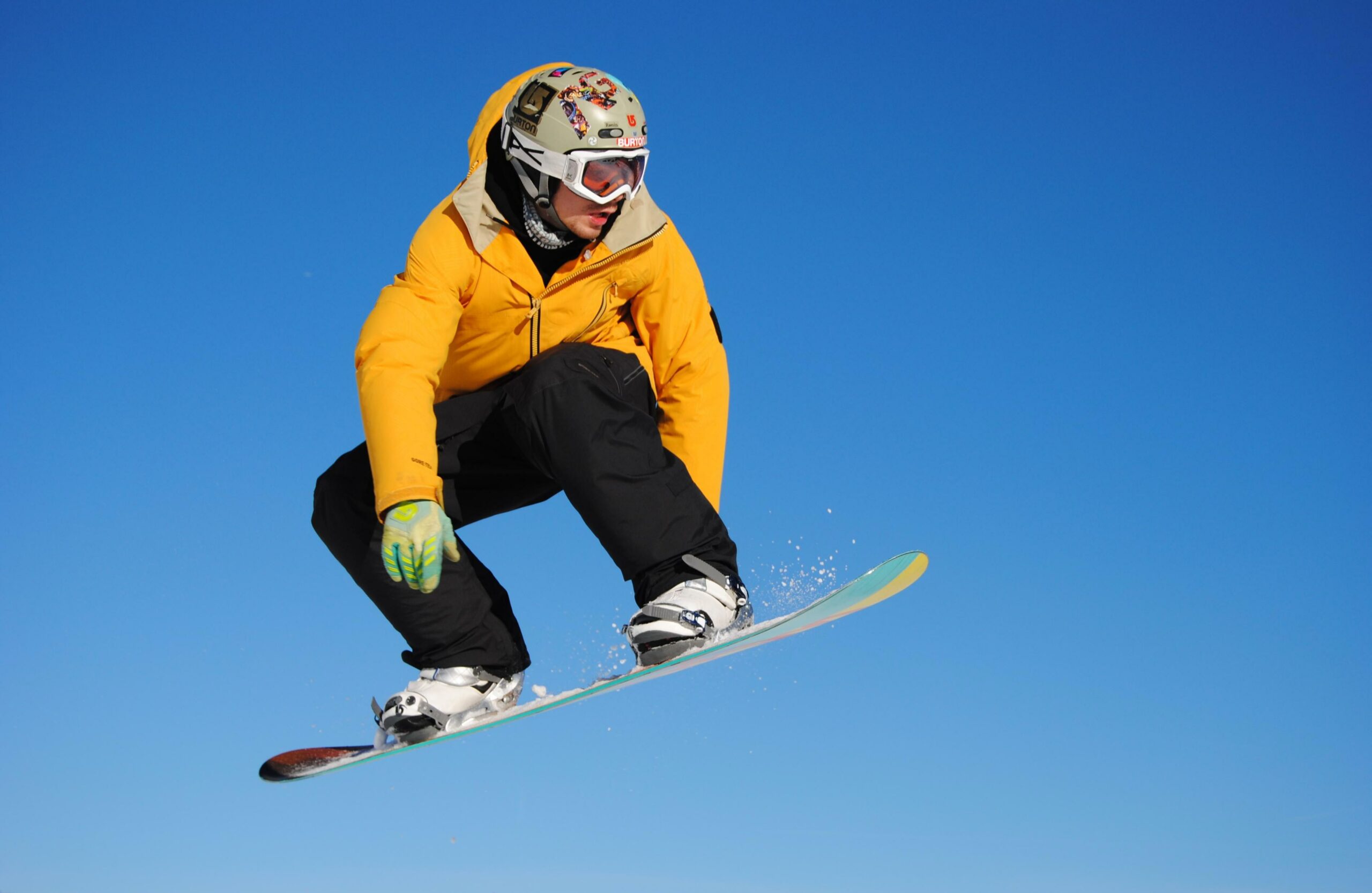 Homme réalisant un saut en snowboard